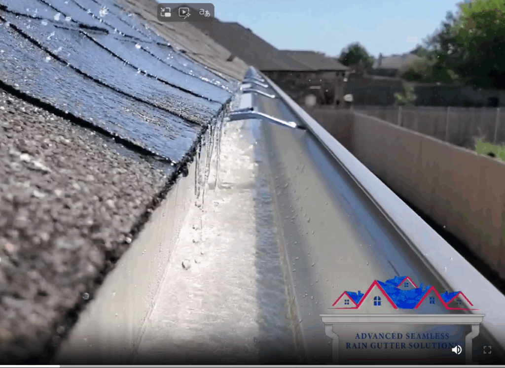Close-up of rainwater flowing off a roof into a newly installed seamless aluminum gutter system