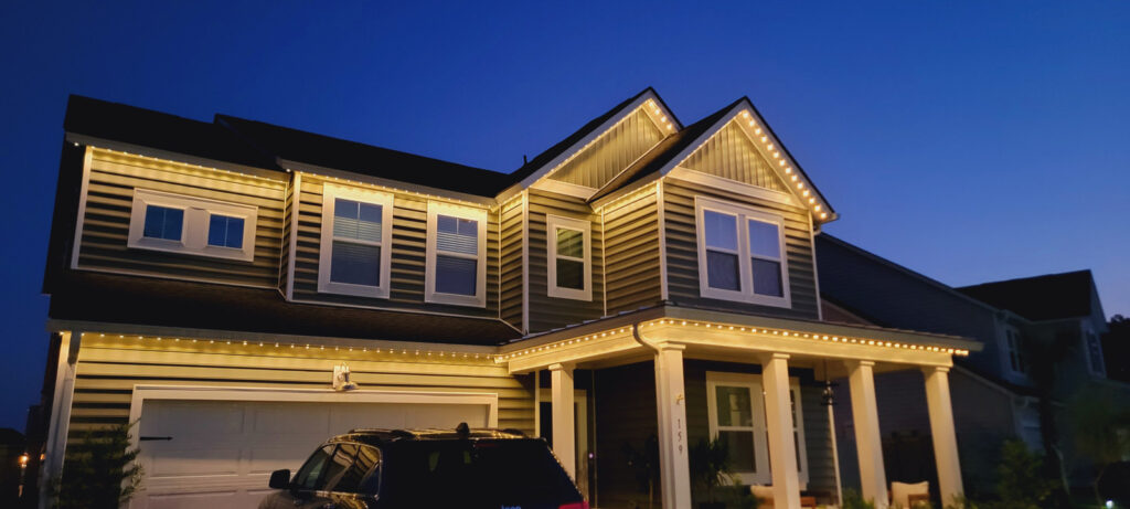 Warm white permanent exterior accent lighting outlining a home roofline in the evening